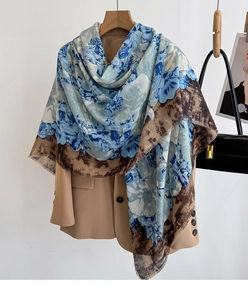Detail of floral printed shawl with frayed edges styled on a beige suit jacket