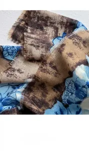 Close-up of vintage floral print scarf with natural frayed edges and blue-brown texture