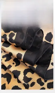 Close-up detail of leopard print scarf showing the professional stitched edge craftsmanship