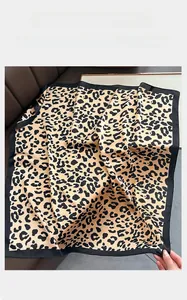 Macro shot of faux silk leopard print square scarf with a sleek black border detail