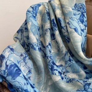 Detail of blue floral print on soft cotton linen scarf with elegant fringe texture