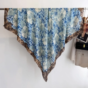 Blue floral and leopard print cotton-linen scarf displayed in a luxury fashion setting