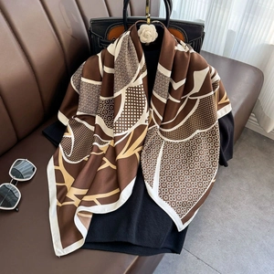 Brown geometric stripe silk scarf draped elegantly over a black outfit for chic styling