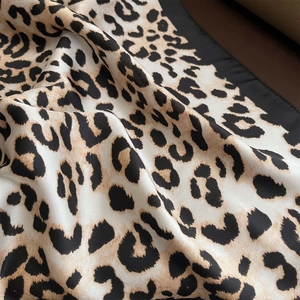 Close-up of lightweight leopard print silk scarf with black border showing smooth texture