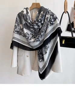 Detail view of lightweight black and white palm tree print scarf on white blazer