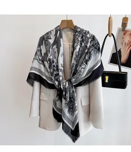 Detail of tropical palm leaf print scarf with frayed edges styled on a beige blazer