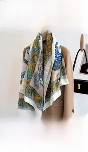 Detail of printed silk scarf with yellow, royal blue and feather patterns and rolled edges