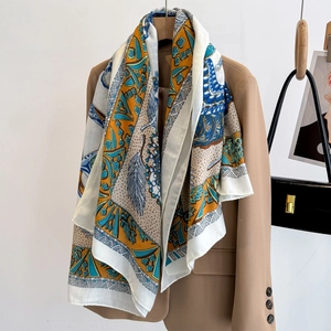 Bohemian large scarf with feather prints styled on a blazer for elegant summer protection