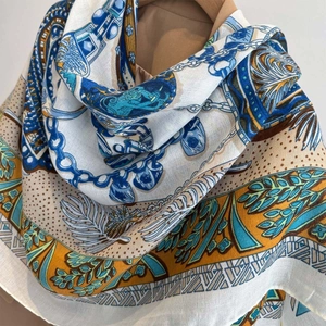Detail of the printed silk scarf showing chain and feather patterns with a soft drape