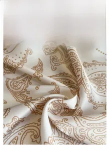 Detailed view of white satin scarf featuring elegant brown paisley print texture