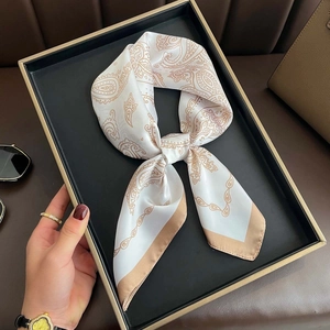 Ivory silk-like square scarf with paisley and chain print displayed in a luxury setting