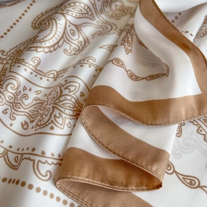 Detailed macro shot of paisley pattern silk scarf with hand-rolled edges and chain print