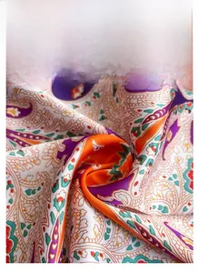 Close-up of a satin paisley scarf with intricate patterns in purple and orange