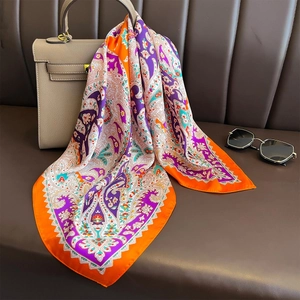 Vintage paisley print silk square scarf in purple and orange draped on a handbag