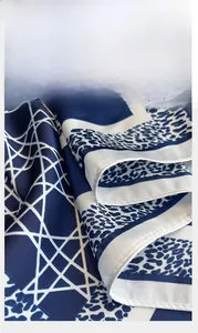 Close-up showing the precise overlock edge stitching on a silk-like geometric scarf