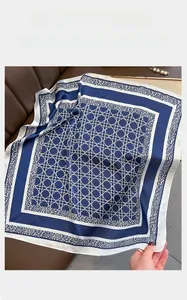Close-up of geometric pattern silk scarf with leopard print edge on leather surface