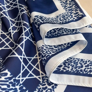 Detailed view of dark blue and white silk-like scarf featuring leopard print and geometric lines