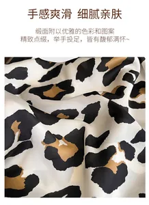 Detail of silk-like satin fabric with leopard print showing smooth texture and sheen
