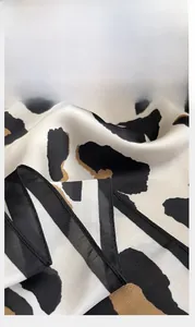 Close-up of leopard print silk scarf showing high-density delicate stitched edge detail