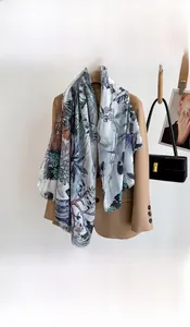 Close-up of light blue floral printed scarf with fringe edge on a beige suit