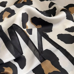 Luxurious leopard print silk square scarf with golden tones and black hemmed edges