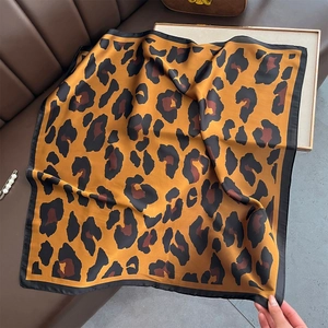 Detailed view of leopard print silk scarf showing smooth texture and fine black hem stitch