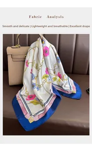 Detail of silk satin scarf with gold chains and pink flowers draped on a classic bag