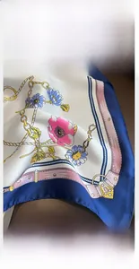 Detail showing high-quality hand-rolled edges and elegant chain pattern on silk scarf
