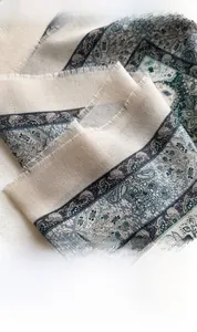 Detailed view of paisley print scarf featuring intricate patterns and soft fringe edges