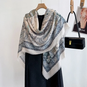Chic paisley print scarf with fringe edges styled with black dress and leather handbag