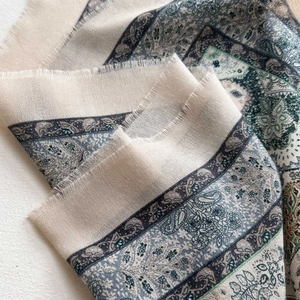 Detailed close-up of paisley print shawl with soft texture and delicate fringe edges