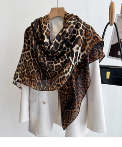 Classic leopard print shawl draped over a white blazer showing soft textile texture