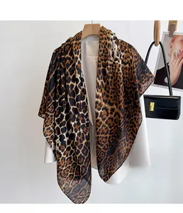 Detail of leopard print scarf draped over white blazer with a natural hang and soft texture