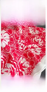 Close-up of red and white floral silk scarf showing precise white stitching on the edge