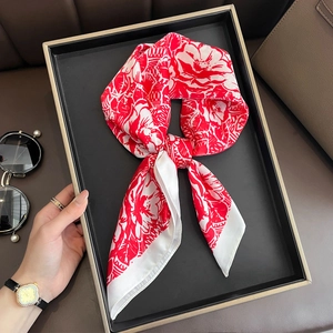 Elegant red and white floral silk scarf displayed as a fashion accessory on a tray