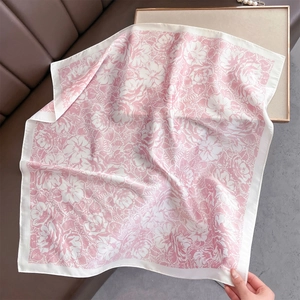 Detail of pink floral silk scarf on a brown leather sofa with decorative pearls