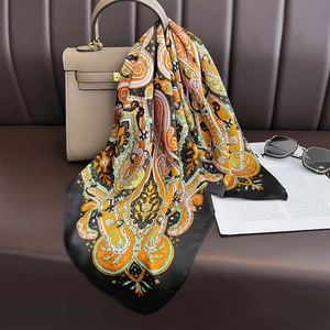 Retro paisley faux silk scarf in black tied to a leather handbag for styling