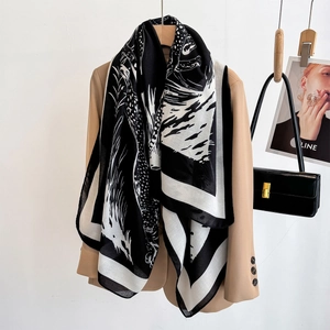 Minimalist black and white leopard print large scarf styled over a beige blazer