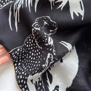 Detailed macro shot of a black leopard print shawl showing the soft fabric texture