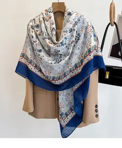 Detail of bohemian floral print scarf draped over a classic khaki blazer with rich textures