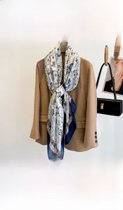 Detail of floral printed scarf in blue and orange tied on a brown blazer collar