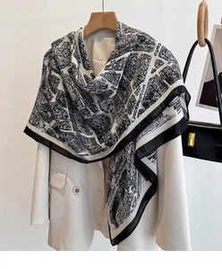 Dettaglio di una grande sciarpa con stampa urbana bianca e nera su un blazer beige
