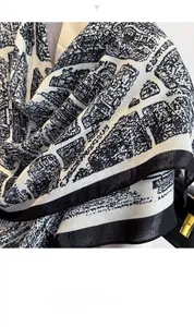 Dettaglio di un foulard in seta con stampa architettonica nera e bordi a contrasto