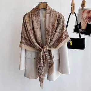Ethnic paisley print square scarf in apricot draped over a white blazer for elegant style
