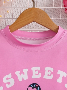 Pink short sleeve t-shirt for girls featuring Sweet text and heart graphic on a wooden hanger