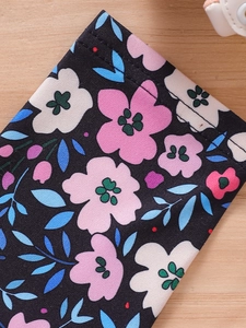 Close-up of black floral fabric with pink and red flowers for toddler girls' outfit