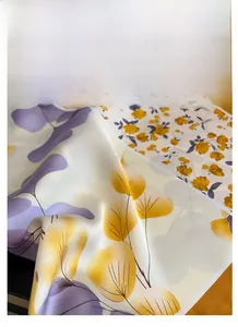 Detail of satin floral scarf fabric showing soft yellow and lilac floral patterns