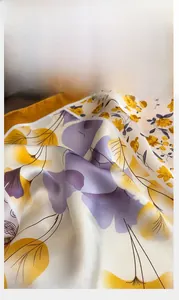 Close-up of floral satin scarf showing silk texture and high-quality stitched edges