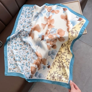 Detailed macro view of the floral patterns and satin texture on the square silk scarf