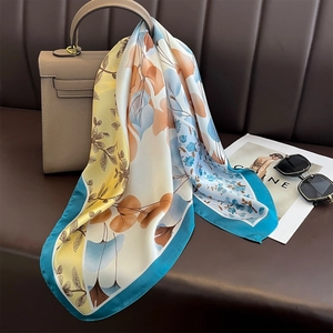 Elegant floral silk satin square scarf with yellow and blue gradient print on handbag